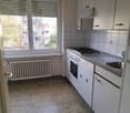modern kitchen with white cabinets, tiled floor, gas stove, oven, sink, window with blinds