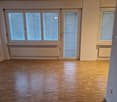 empty room, wooden floor, white walls, two windows, two doors, radiators