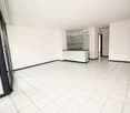 White tiled floor, white walls, sliding door, countertop, cabinets, sink, light