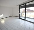 empty room, white tiles, sliding glass door leading to balcony