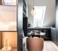 small kitchen, round table, single chair, round pendant light, countertop, sink, oven, bench, storage