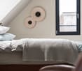 Bedroom: twin bed, knitted blanket, pillows, 2 lamps, 2 windows