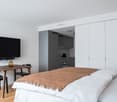 Bed, television, table, cabinets, wooden floor