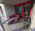 Balcony with a couch, a table, and a grill