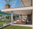 two story apartment, balcony with fence and tree, wooden couch and chairs, dining table, mountain view
