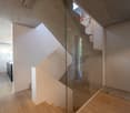wooden floors, glass staircase, concrete walls, open area, large window