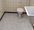 White tiled walls, white tiled floor, toilet, sink