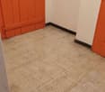 room with white walls, tile floor, and wooden orange doors.