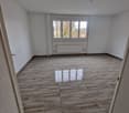 Empty room, wooden floor, white walls, large window