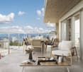 spacious balcony with wooden furniture, dining set, plants, modern fixtures, city view