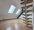 Empty room, wooden floor, radiator, spiral staircase, 2 skylights