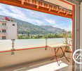 Balcony with a view of the mountains and surrounding buildings, table and potted plant on the balcony