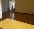 Empty room with hardwood floors, white walls, and a sliding glass door leading to the outside