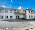 Two story commercial building, modern architecture, concrete construction, large windows, open parking area in front