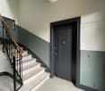 marble staircase, wooden handrail, tiled floor, entrance door, painted walls, switch box