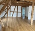 empty room, wooden beams, hardwood floors, white walls, white doors, small window