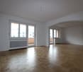 empty room with white walls, wooden floors, large windows