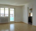 Empty room with hardwood floors, sliding doors, and balcony access, a window, and a balcony