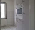 kitchen with white appliances, tiled floor, radiator