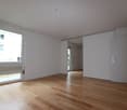 empty room with large windows, sliding doors, wooden floor, radiator