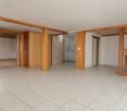 tiled floor, large room, wooden pillars, glass door, white walls, large windows