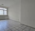 empty room, white walls, tiled floor, large window, white radiator