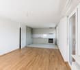 Hardwood floors, white walls, modern kitchen, open door, large glass window with balcony