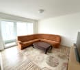 white walls, wooden floor, large sofa, TV, carpet, windows, table