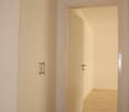 Empty room, white walls, wood floor, white door, tall white cabinet