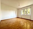 Empty room with wooden floor, white walls, single window