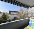 Balcony with railings, awning, and a view of the house and surroundings