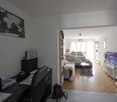 Desk, chair, laptop, books, backpack, world map, TV, couch, coffee table, rug, shelves, plants, windows