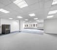 empty room, white walls, gray carpet, white ceiling with lights, windows, server rack