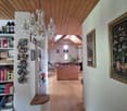 Wooden floor, wooden ceiling, chandelier, bookshelves, wall paintings, hallway leading to living room