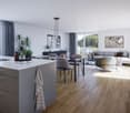 Open-concept living room and dining area with large windows, hardwood floors, gray sofa and chairs, dining table, kitchen island, and decorative plants
