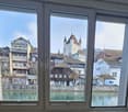 Window overlooking a river and buildings with medieval-style architecture