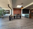large room, wooden desk, chairs, brick wall, world map, radiator, lamps, wooden floor