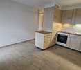 modern kitchen with wooden cabinets, tiled floor, sink, oven, dishwasher, washing machine