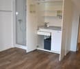 small room with open closet, bathroom, sink, faucet, washing machine