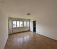 empty room, wooden floor, white walls, large windows, radiator, ceiling lamp