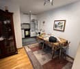 Dining area with a table and chairs, a rug, a cabinet, a refrigerator, a microwave, a picture frame, and a ceiling lamp