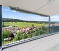 modern apartment, balcony with railing, open view of a valley and houses