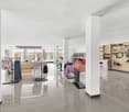 minimalistic store interior with white walls, white pillars, glass displays, bicycles and clothing items on hangers