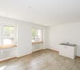 empty room, white walls, wooden floor, double window, radiator, small sink with cabinet