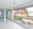 balcony with sliding glass doors, white tiled floor, metal railings, outdoor view, empty room