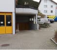 Apartment building with garage and parking entrance.