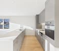 Modern kitchen with white countertops, gray cabinets, large windows, and integrated appliances.