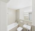 Bathroom with bathtub, toilet, sink, mirror, and shower