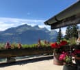 Mountain view from balcony, outdoor planter boxes with flowers, hanging flower pots