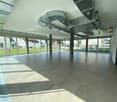 large open space, tiled floor, large windows, metal beams, ventilation ducts